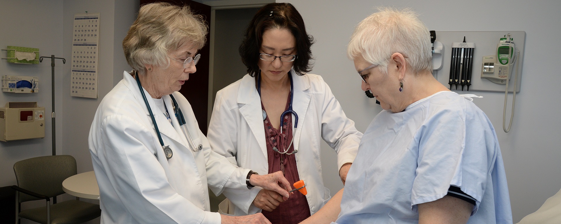 A DNP nurse being instructed on proper technique for checking reflexes with an older patient.